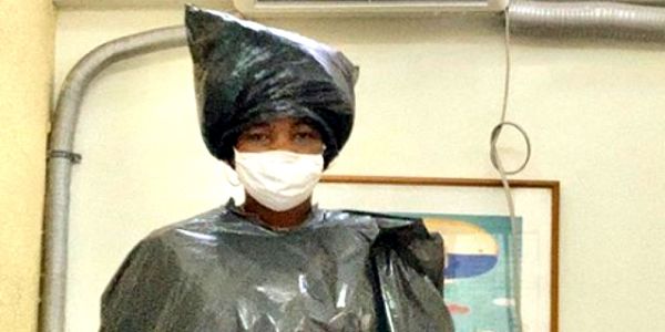 Paciente veste saco de lixo para realizar cirurgia em consultório odontológico